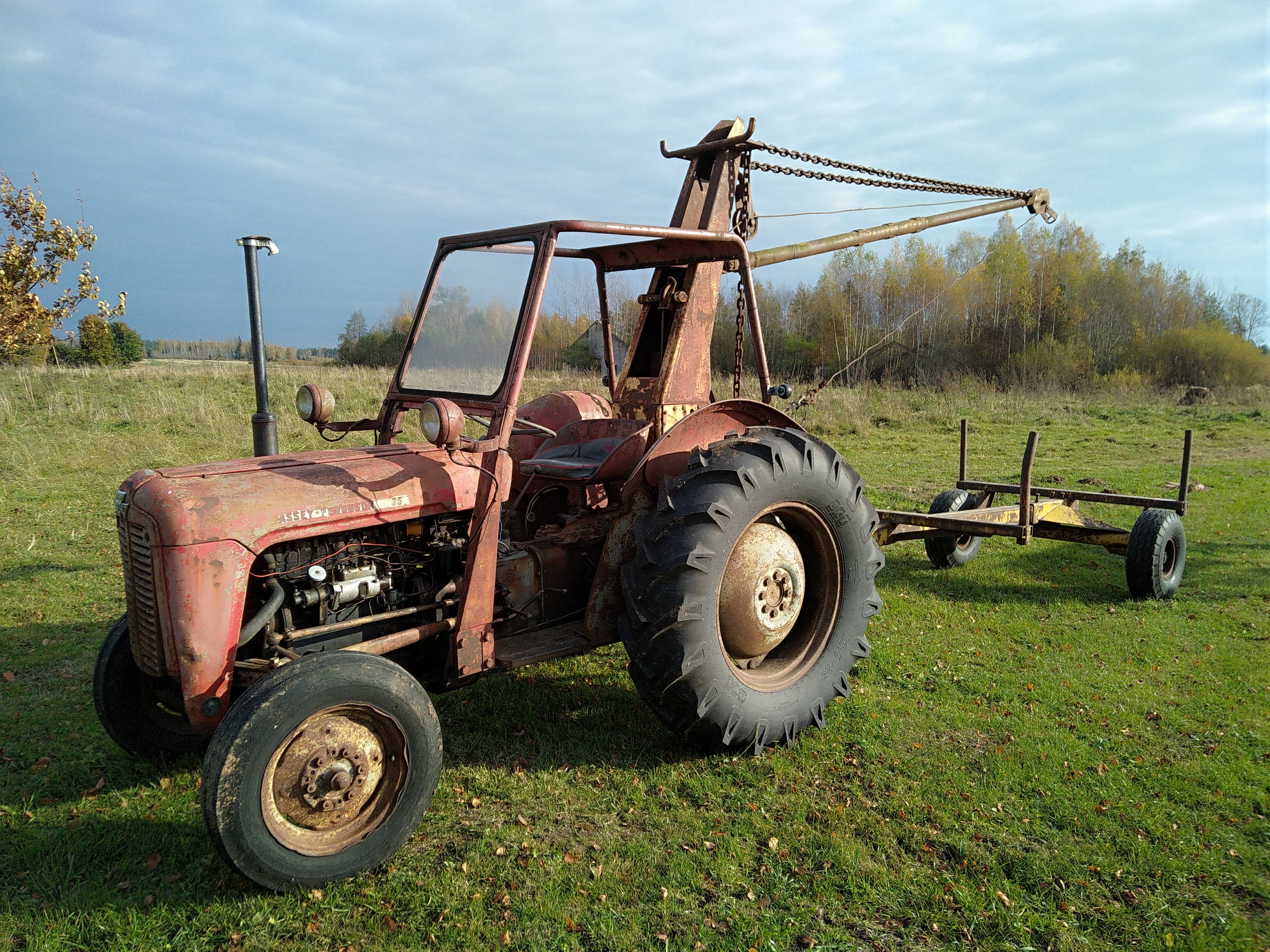 Traktors malkas sagadei ar krānu un vinču